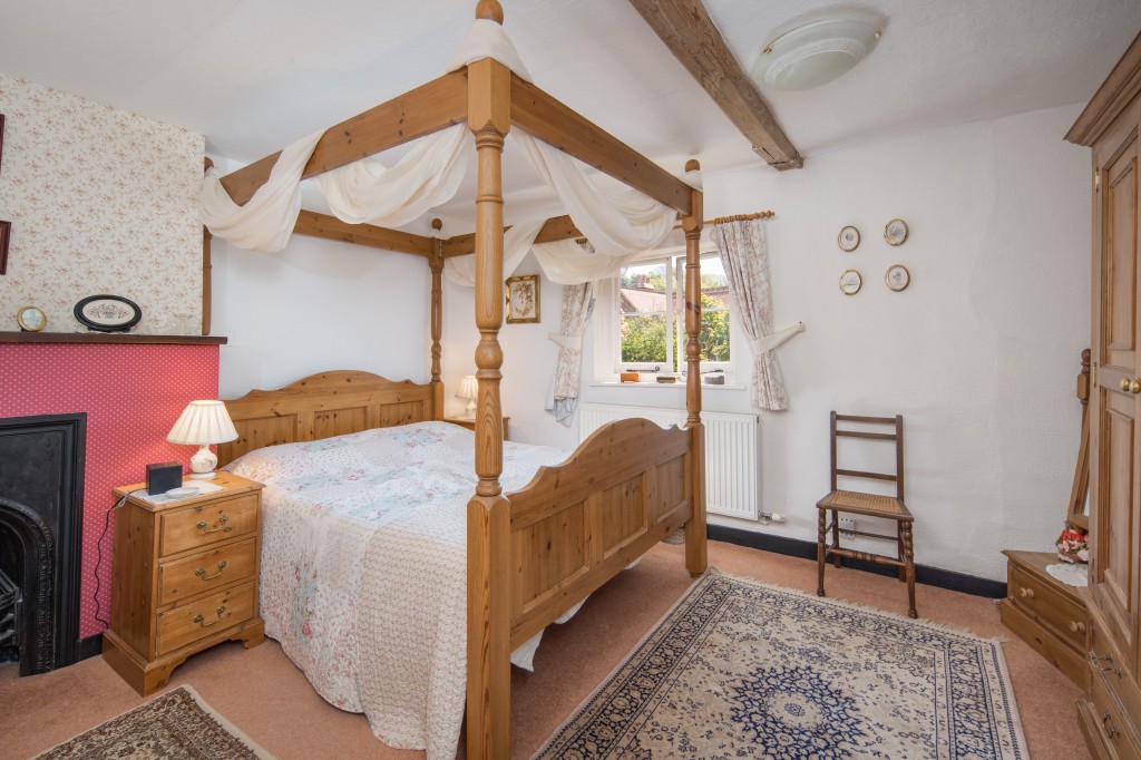 Lot: 108 - CHARMING COTTAGE WITH SELF-CONTAINED ANNEXE, GARDENS AND GARAGE - Bedroom with four poster bed